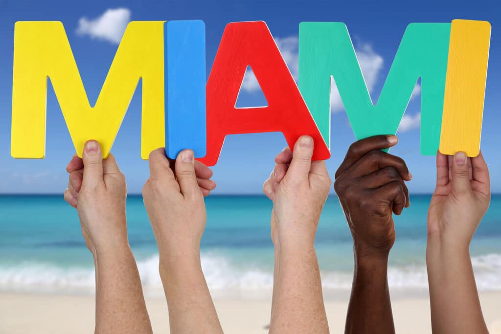 Hands Holding The Word Miami In Summer On Beach